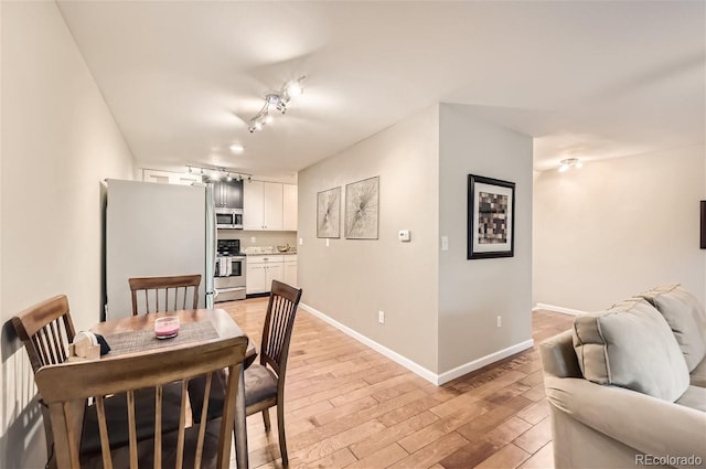 dining room featuring rail lighting and light wood-type flooring