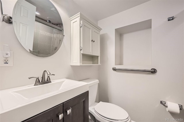 bathroom featuring toilet, an enclosed shower, and vanity