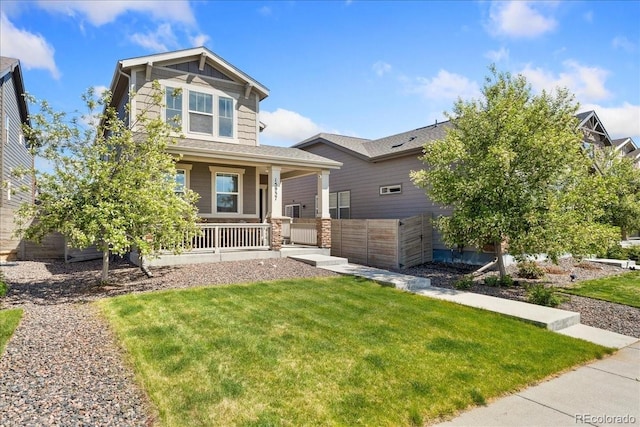 craftsman inspired home featuring a porch, fence, and a front yard