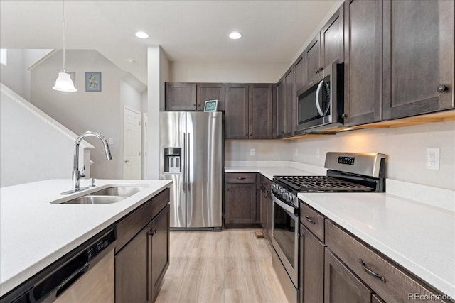 kitchen with hanging light fixtures, dark brown cabinets, a sink, light countertops, and stainless steel appliances