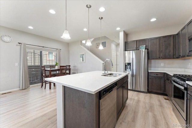 kitchen featuring visible vents, dark brown cabinets, a sink, light wood-style flooring, and stainless steel appliances