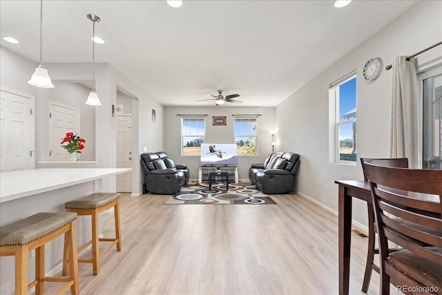 living area with baseboards, a ceiling fan, recessed lighting, and light wood-style flooring