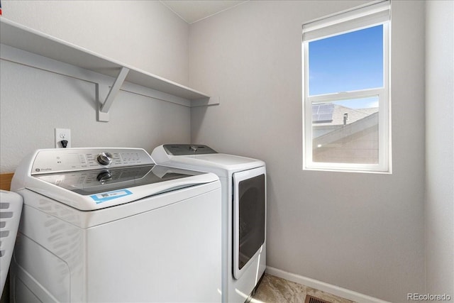 washroom with baseboards, laundry area, and independent washer and dryer