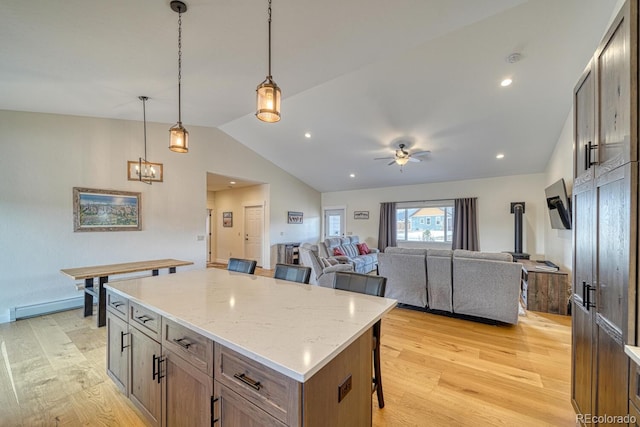 kitchen featuring lofted ceiling, a breakfast bar, light wood-style flooring, and a center island