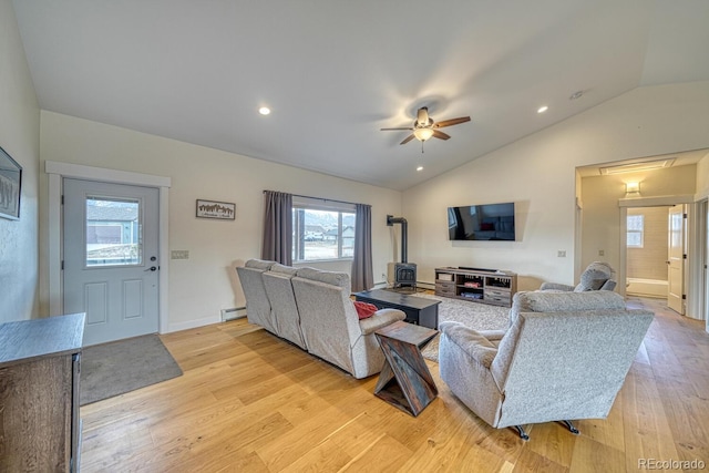 living room with a ceiling fan, lofted ceiling, light wood-type flooring, a baseboard heating unit, and recessed lighting