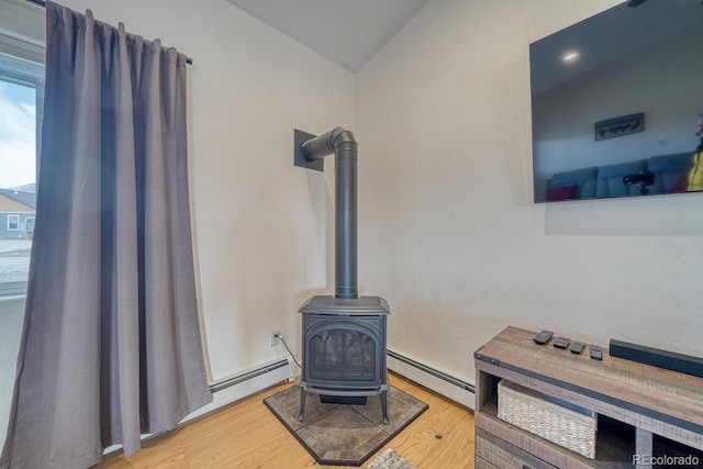 interior details featuring a baseboard heating unit, wood finished floors, and a wood stove