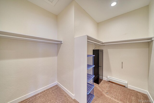 walk in closet with carpet and a baseboard heating unit