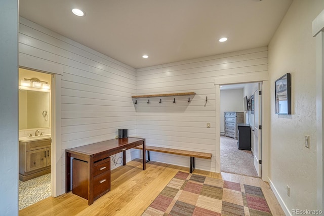 mudroom with baseboards, recessed lighting, a sink, and light wood-style floors