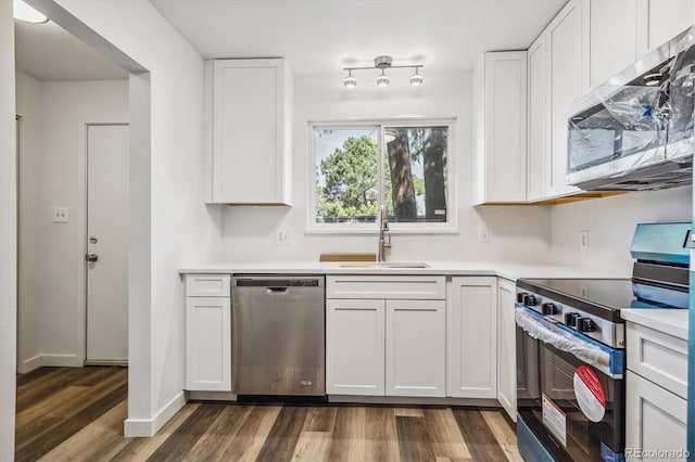 kitchen with white cabinets, stainless steel appliances, sink, and dark hardwood / wood-style floors