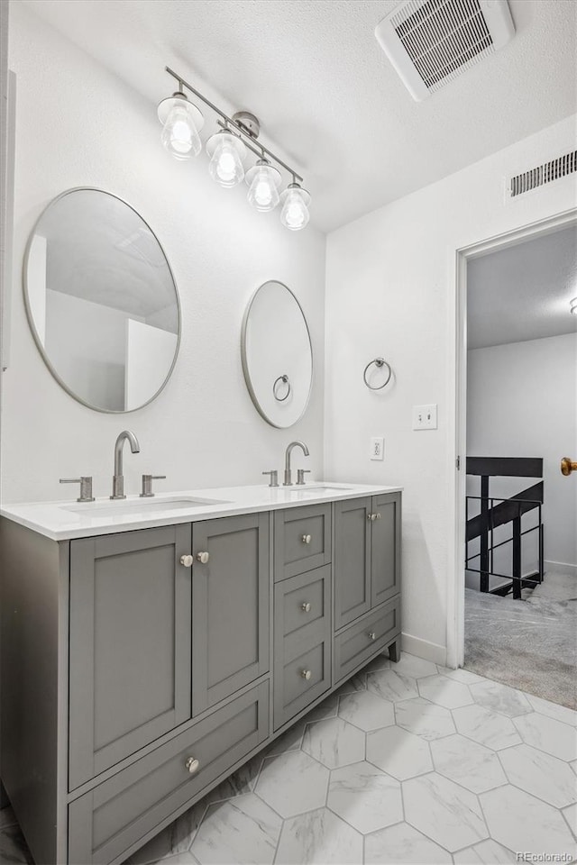 bathroom featuring a textured ceiling and vanity