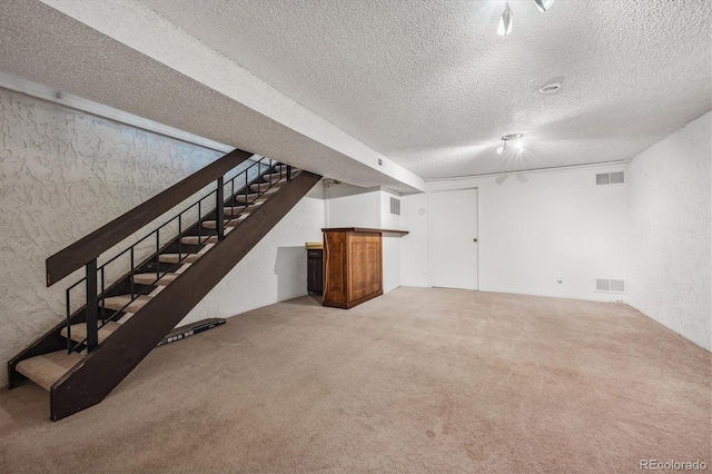 basement with a textured ceiling and carpet floors