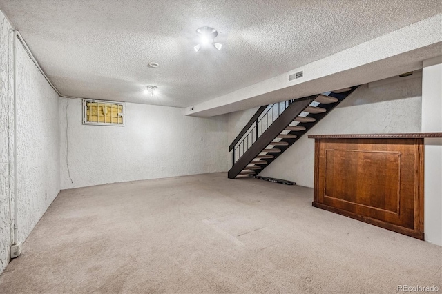 basement featuring carpet flooring and a textured ceiling