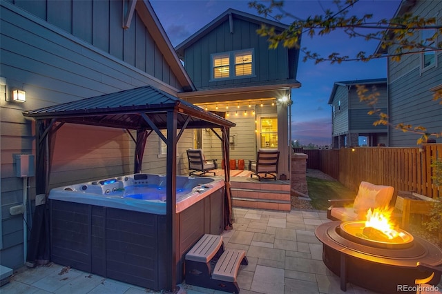 8444 E 55th Pl, Denver, CO 80238 - patio terrace at dusk featuring a hot tub, a gazebo, a fire pit, and fence private yard