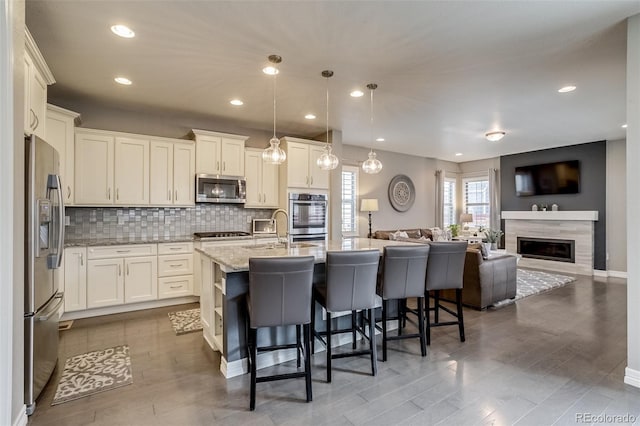 8444 E 55th Pl, Denver, CO 80238 - kitchen with open floor plan, a kitchen bar, tasteful backsplash, light stone counters, and stainless steel appliances