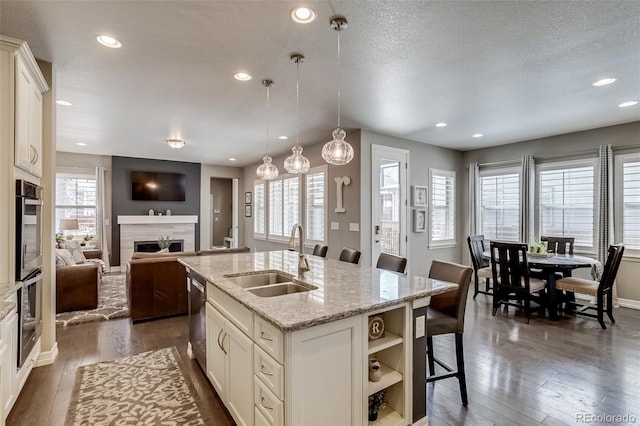 8444 E 55th Pl, Denver, CO 80238 - kitchen with a fireplace, open shelves, a sink, stainless steel appliances, and recessed lighting