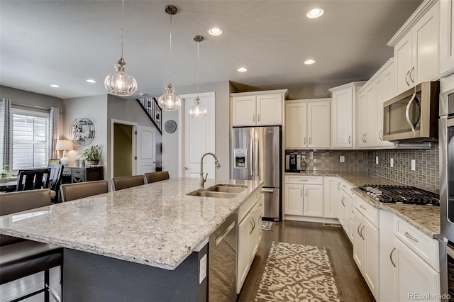 8444 E 55th Pl, Denver, CO 80238 - kitchen featuring appliances with stainless steel finishes, dark wood-type flooring, recessed lighting, light stone countertops, and tasteful backsplash