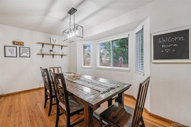 12261 N Holly Way, Brighton, CO 80602 - dining area with light wood-style floors, a chandelier, and baseboards