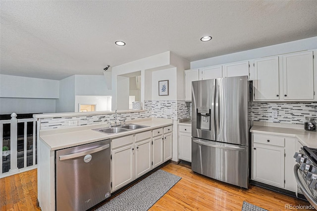 12261 N Holly Way, Brighton, CO 80602 - kitchen with stainless steel appliances, a sink, tasteful backsplash, light countertops, and a peninsula