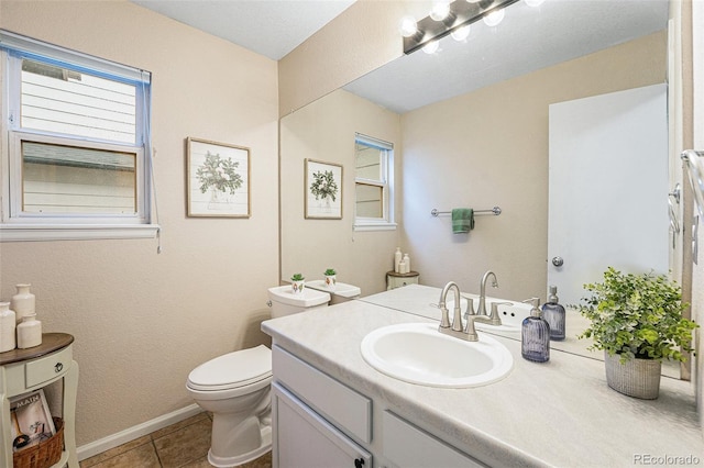 12261 N Holly Way, Brighton, CO 80602 - bathroom featuring toilet, vanity, and tile patterned flooring