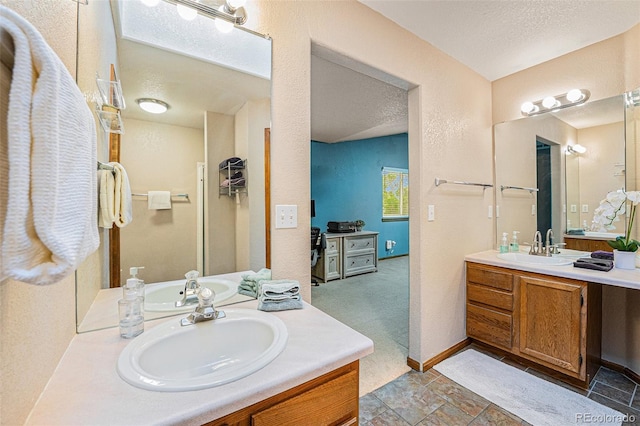 12261 N Holly Way, Brighton, CO 80602 - full bathroom featuring two vanities, a textured wall, and a textured ceiling
