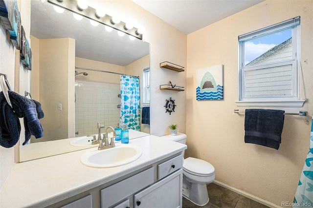 12261 N Holly Way, Brighton, CO 80602 - full bath featuring toilet, vanity, a shower with curtain, baseboards, and tile patterned flooring