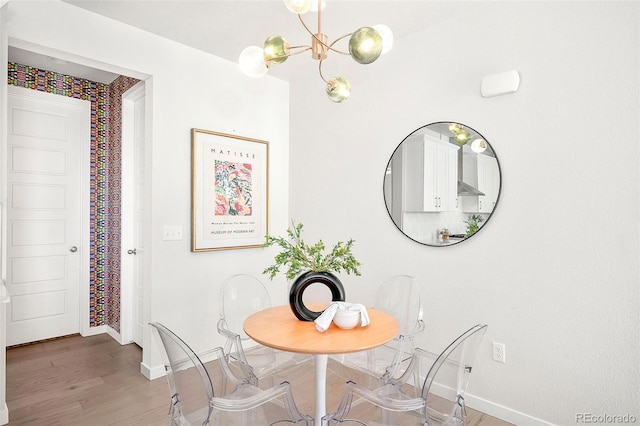 dining space with wood-type flooring and a notable chandelier