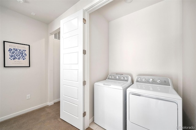 washroom with washing machine and dryer and light carpet