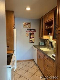 kitchen featuring dishwasher, stove, sink, and light tile patterned flooring