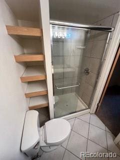 bathroom featuring an enclosed shower, tile patterned floors, and toilet