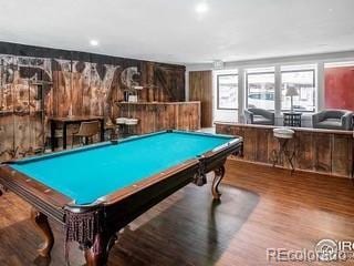 recreation room featuring hardwood / wood-style flooring, pool table, and bar