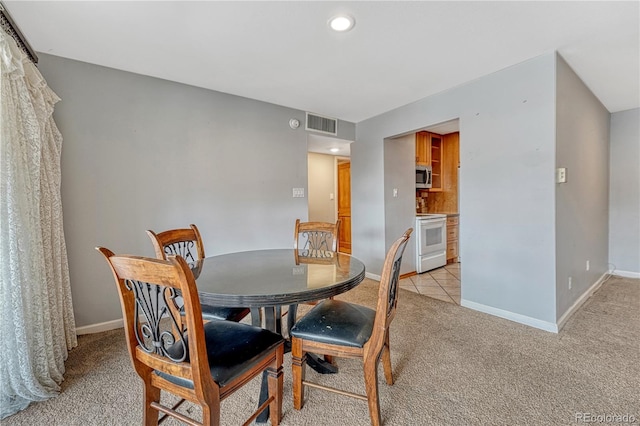 dining space with visible vents, light carpet, and baseboards