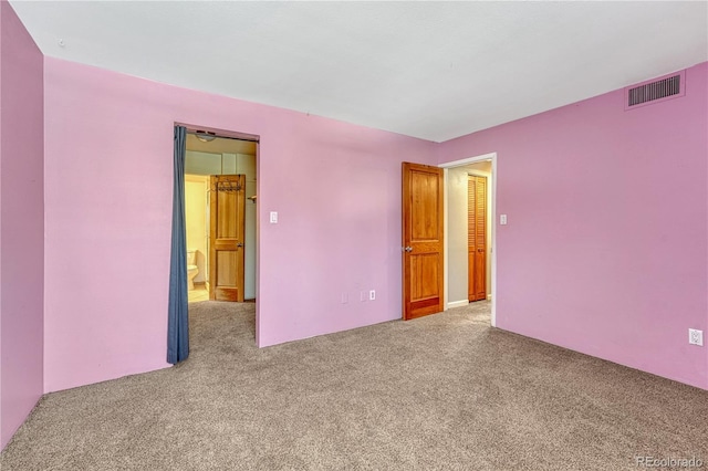 carpeted empty room featuring visible vents