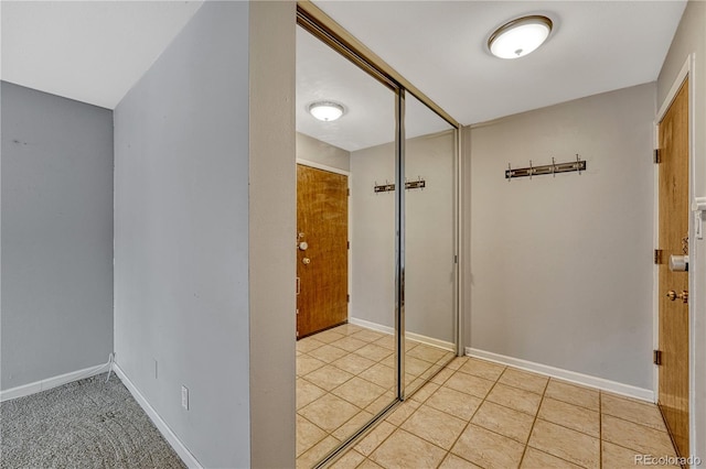 hallway featuring light tile patterned floors and baseboards