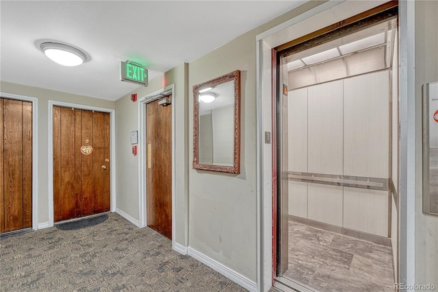 hallway with elevator and baseboards