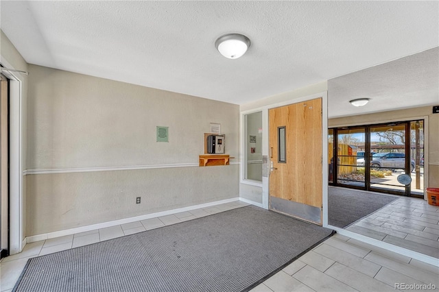 spare room with a textured ceiling and light tile patterned floors