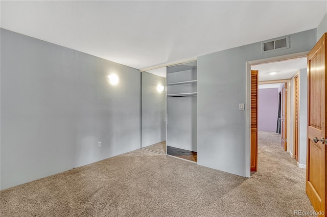 unfurnished bedroom featuring carpet, a closet, and visible vents