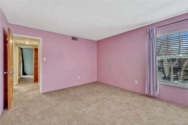 unfurnished room featuring light carpet and visible vents