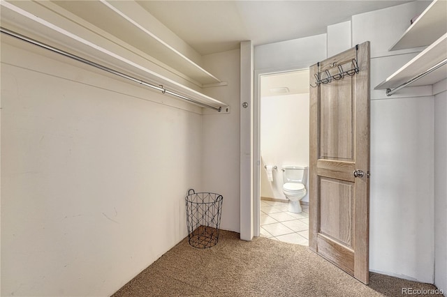 spacious closet with carpet floors and tile patterned flooring