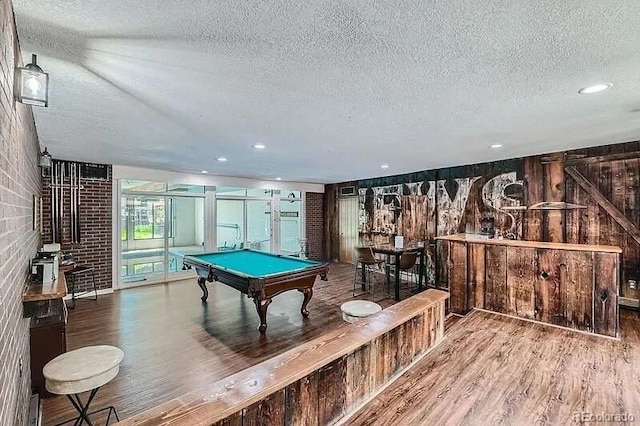 playroom with recessed lighting, a textured ceiling, brick wall, wood finished floors, and billiards