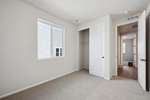 unfurnished bedroom featuring light carpet and a closet