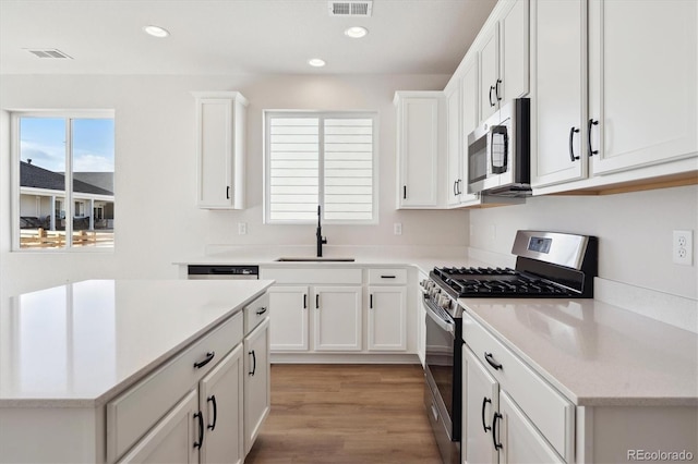 kitchen featuring white cabinetry, stainless steel appliances, light hardwood / wood-style floors, and sink