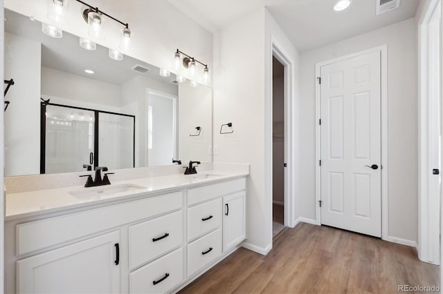 bathroom with vanity, hardwood / wood-style floors, and a shower with shower door