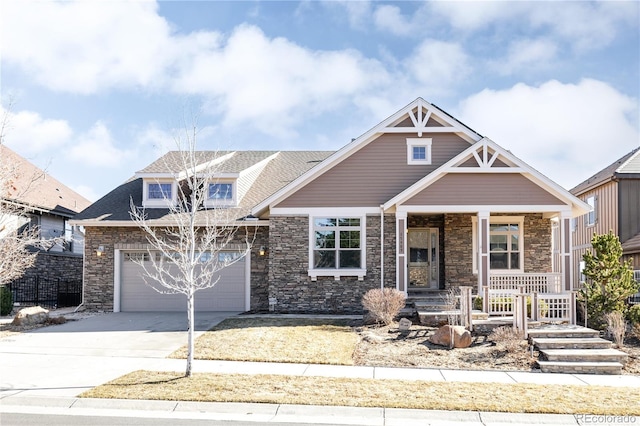 craftsman-style home with covered porch, stone siding, and concrete driveway