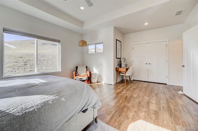 bedroom featuring multiple windows, light hardwood / wood-style flooring, and ceiling fan