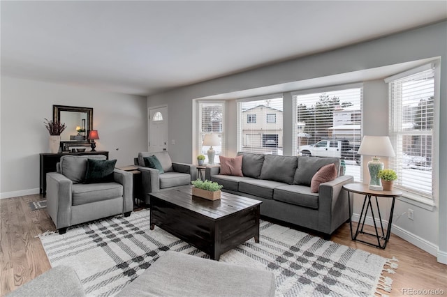 living area with light wood-style flooring and baseboards