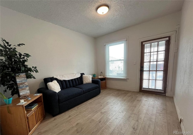 living room featuring a textured ceiling and light hardwood / wood-style flooring