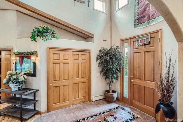 1361 Bross Ct, Evergreen, CO 80439 - entrance foyer with a baseboard heating unit, healthy amount of natural light, and a towering ceiling