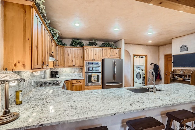 1361 Bross Ct, Evergreen, CO 80439 - kitchen featuring stainless steel appliances, under cabinet range hood, light stone counters, a breakfast bar area, and recessed lighting
