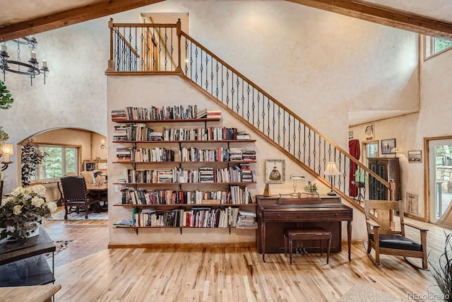 1361 Bross Ct, Evergreen, CO 80439 - living area featuring a towering ceiling, arched walkways, stairs, wood-type flooring, and a chandelier
