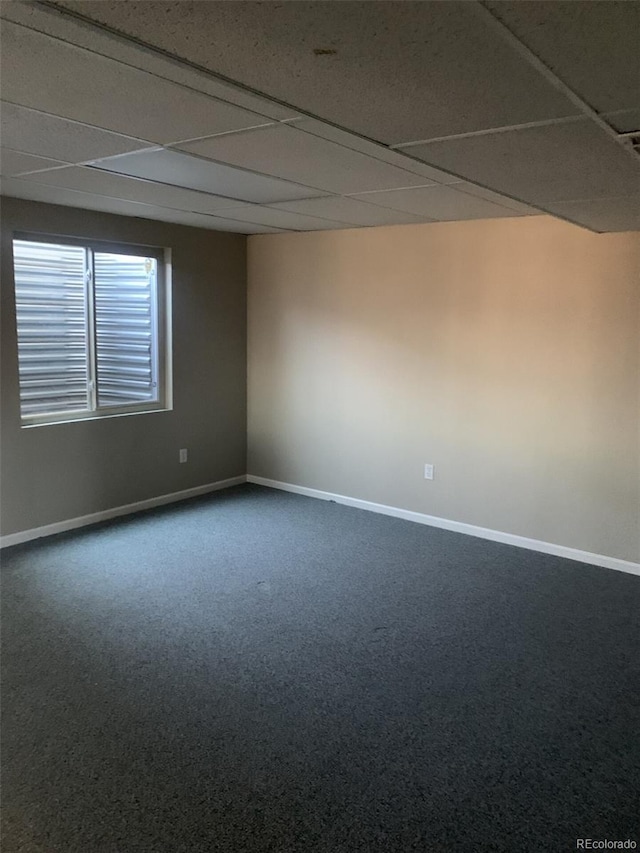 carpeted spare room featuring a paneled ceiling